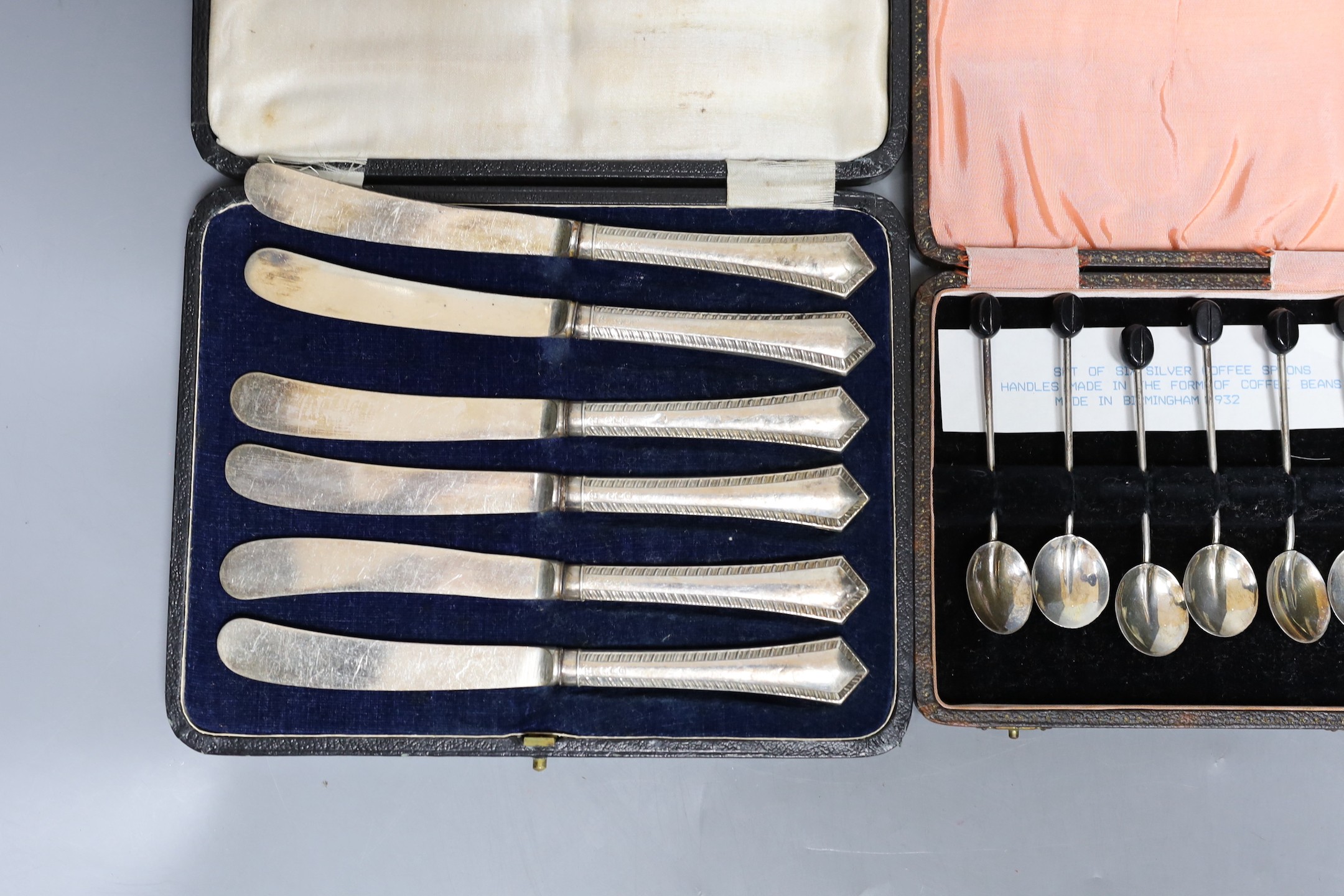 Three assorted cased sets including six silver handled tea knives, six bean end coffee spoons and six sterling cocktail forks.